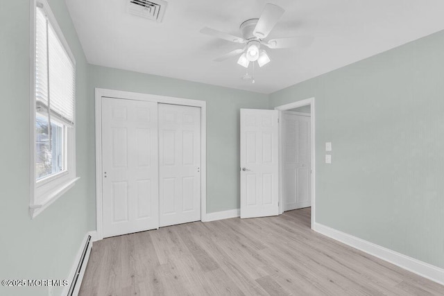 unfurnished bedroom with baseboards, light wood-style flooring, visible vents, and a closet