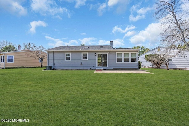 rear view of property featuring a yard, central AC unit, and a patio area