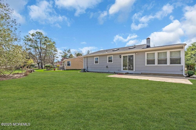 back of house with a chimney, a yard, cooling unit, and a patio