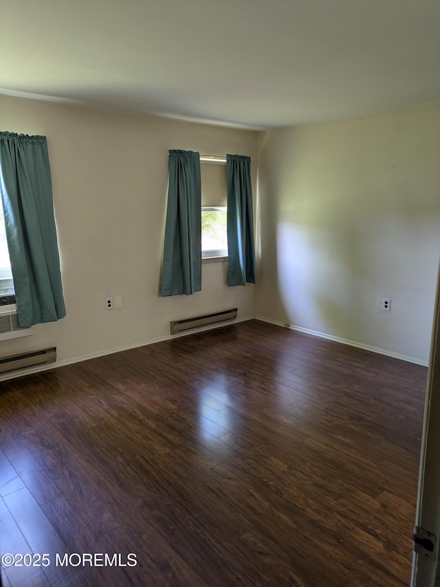 unfurnished room featuring baseboards, a baseboard radiator, and wood finished floors