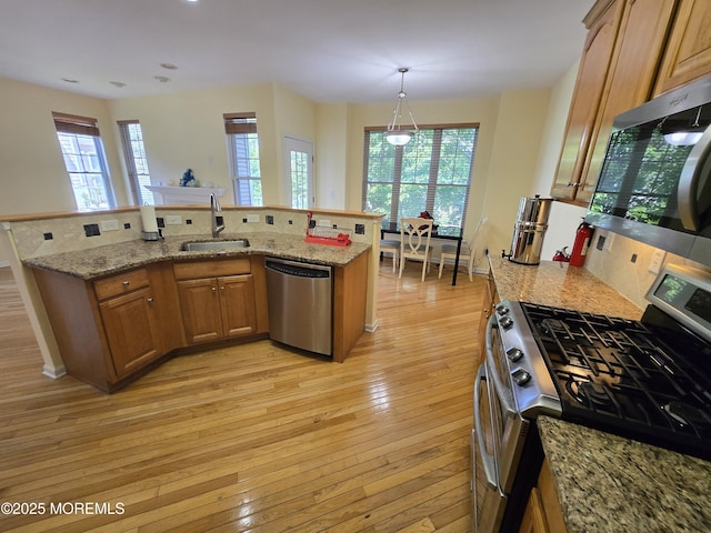 3 Great Beds Way S, Amboy, NJ 08879 - kitchen featuring appliances with stainless steel finishes, a sink, light wood-style floors, brown cabinetry, and light stone counters