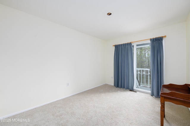 carpeted spare room featuring baseboards