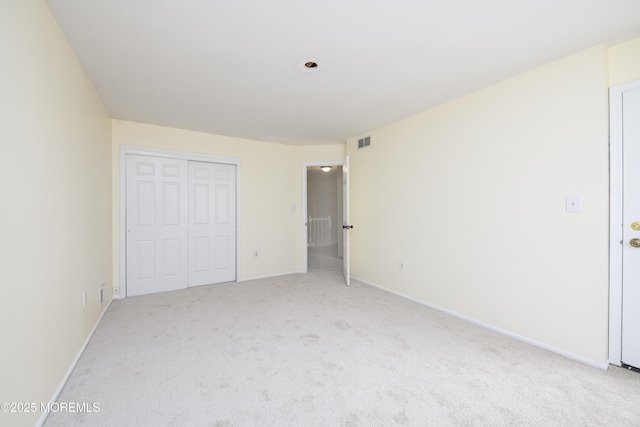 unfurnished bedroom with baseboards, a closet, visible vents, and carpet