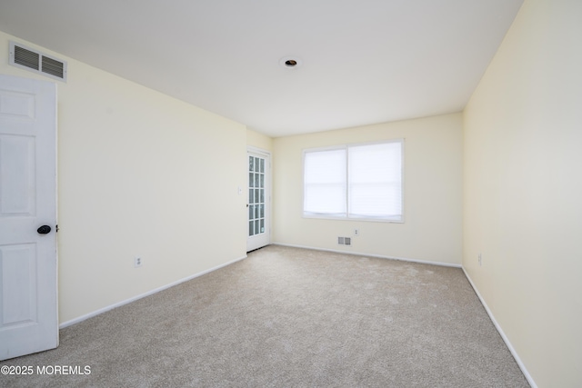 empty room featuring carpet floors, visible vents, and baseboards