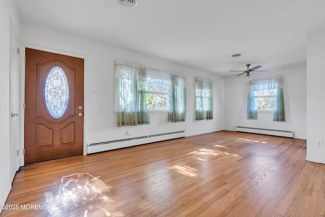 entrance foyer with visible vents, ceiling fan, wood finished floors, and baseboard heating