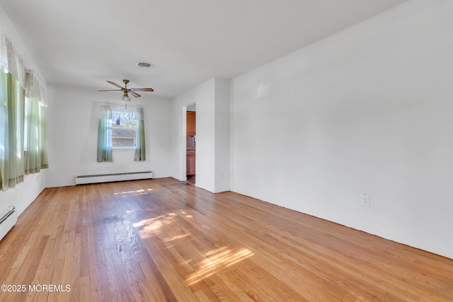 unfurnished room featuring a baseboard radiator, a ceiling fan, light wood-type flooring, and visible vents