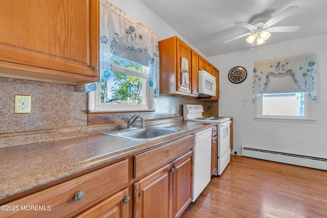 kitchen with tasteful backsplash, brown cabinets, a sink, a baseboard radiator, and white appliances