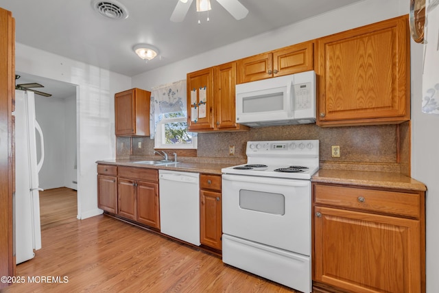 kitchen with ceiling fan, visible vents, tasteful backsplash, a sink, and white appliances