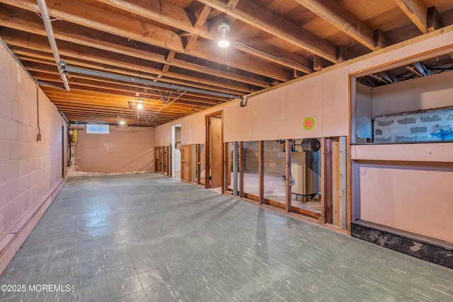 unfinished below grade area featuring concrete block wall and tile patterned floors