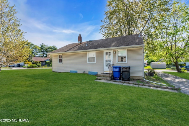 rear view of property with a yard and a chimney