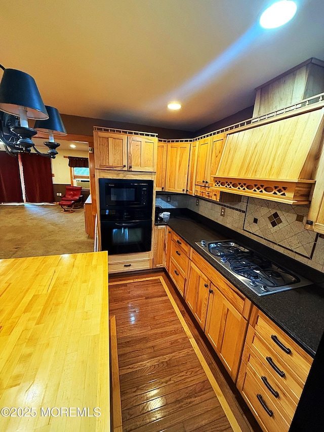 kitchen featuring decorative backsplash, dark countertops, black appliances, dark wood-style floors, and recessed lighting