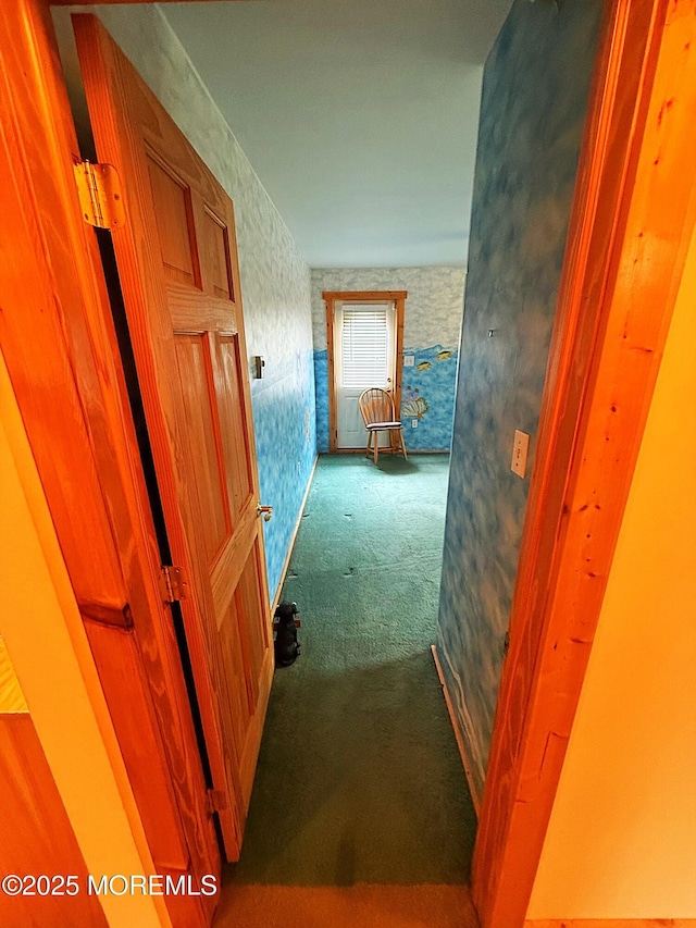 hall with carpet floors and wallpapered walls