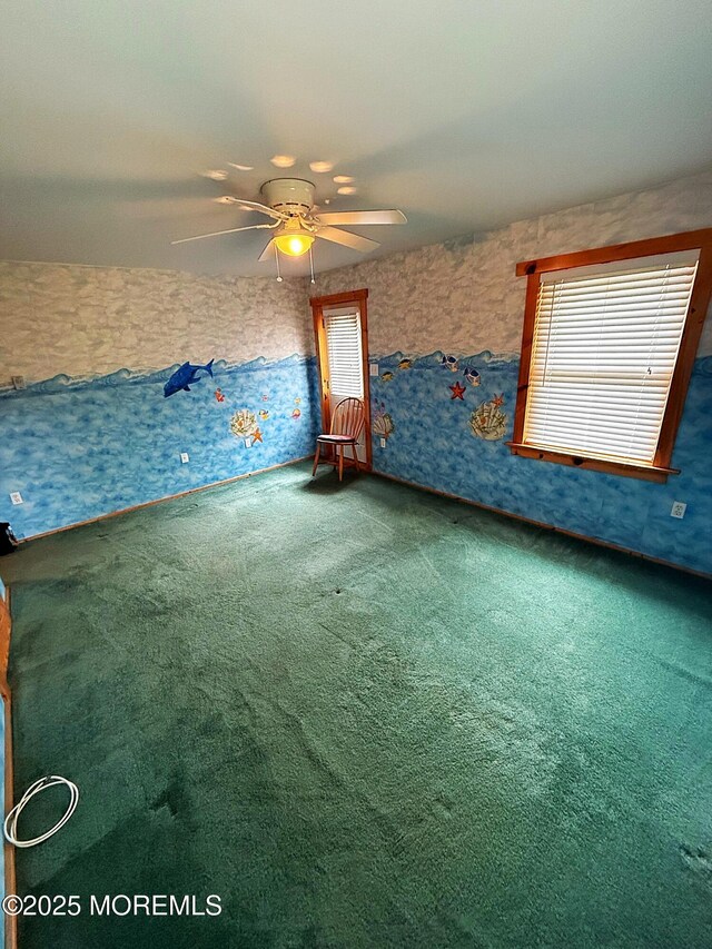 unfurnished bedroom featuring carpet floors, a ceiling fan, and multiple windows