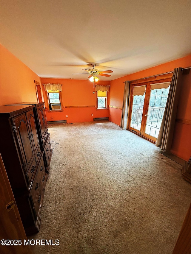spare room with a baseboard radiator, ceiling fan, and light carpet