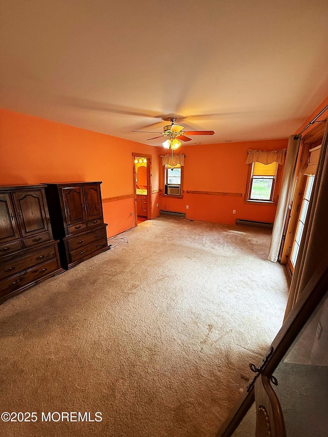 empty room featuring light colored carpet, ceiling fan, a healthy amount of sunlight, and baseboard heating