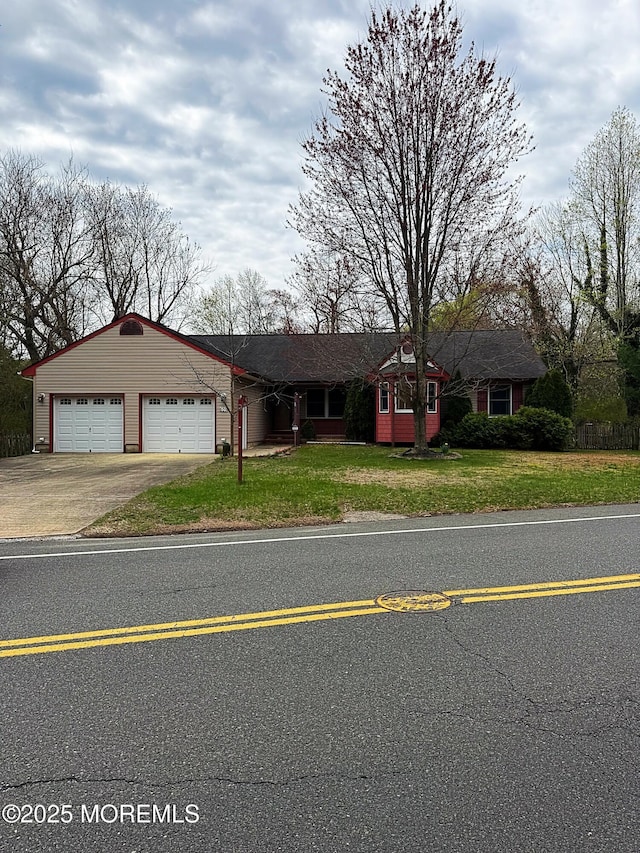ranch-style home with an attached garage, concrete driveway, and a front yard