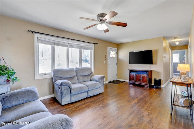 living room with wood finished floors, baseboards, and ceiling fan