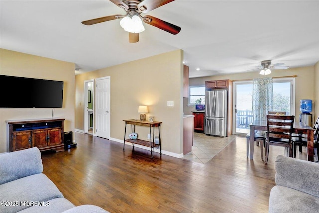 living room with baseboards, a ceiling fan, and wood finished floors