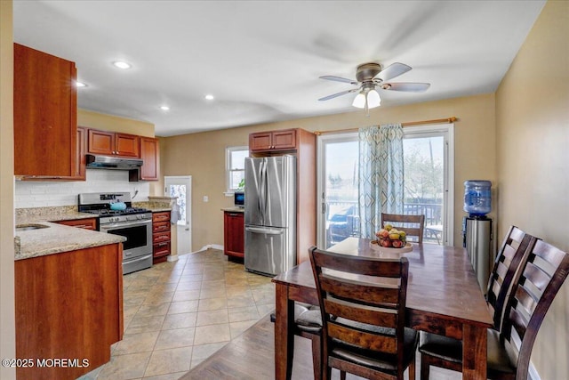 kitchen with under cabinet range hood, backsplash, appliances with stainless steel finishes, and plenty of natural light