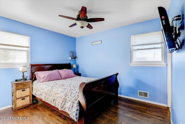 bedroom with baseboards, wood finished floors, and visible vents