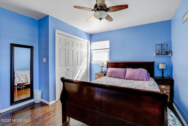 bedroom with baseboards, a closet, ceiling fan, and dark wood finished floors