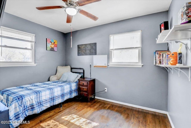 bedroom featuring ceiling fan, baseboards, and wood finished floors