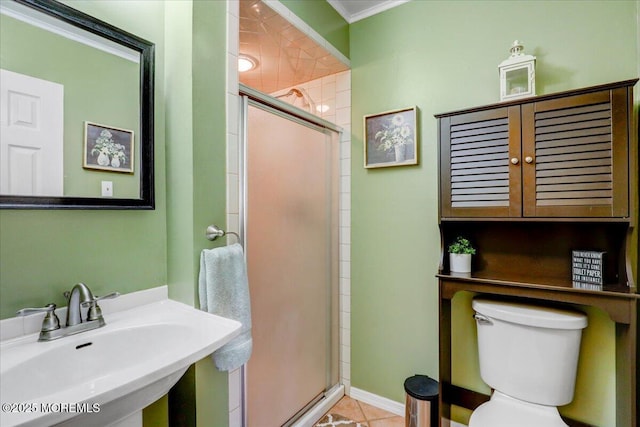 full bathroom with toilet, crown molding, a sink, and a stall shower