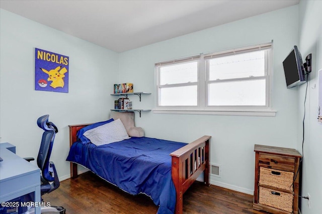 bedroom with visible vents, baseboards, and wood finished floors