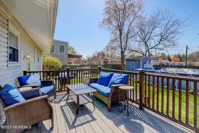 wooden deck featuring a fenced in pool, an outbuilding, a fenced backyard, outdoor lounge area, and a shed