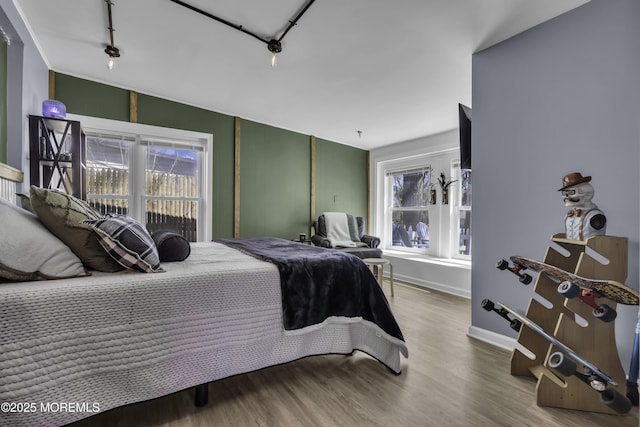 bedroom featuring wood finished floors and baseboards