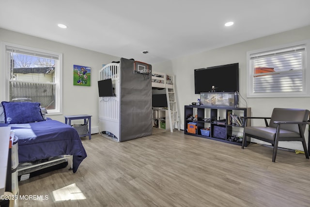 bedroom featuring baseboards, wood finished floors, and recessed lighting