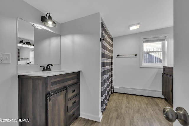 full bathroom with baseboards, vanity, and wood finished floors