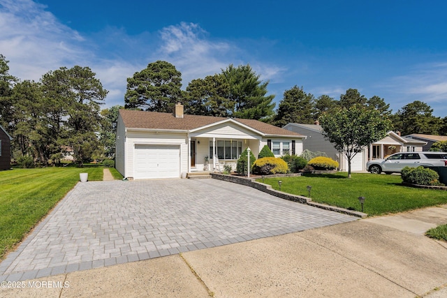 single story home featuring decorative driveway, a garage, a front lawn, and covered porch
