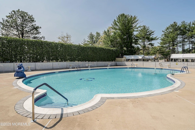 community pool featuring fence and a patio