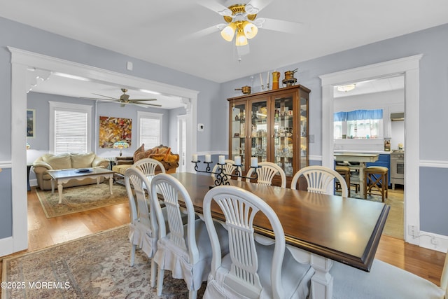 dining area with a ceiling fan and light wood-style floors