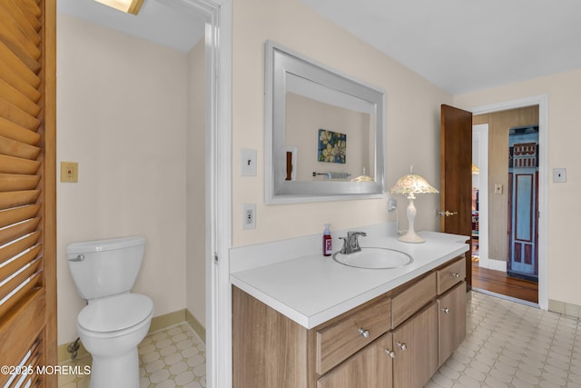 bathroom featuring baseboards, tile patterned floors, vanity, and toilet