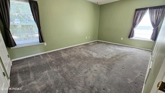 unfurnished room with carpet flooring and baseboards