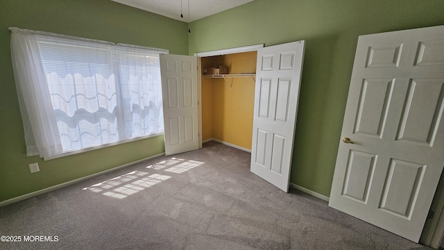 unfurnished bedroom featuring baseboards, carpet floors, and a closet