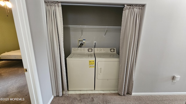 clothes washing area with baseboards, laundry area, light colored carpet, and washer and clothes dryer