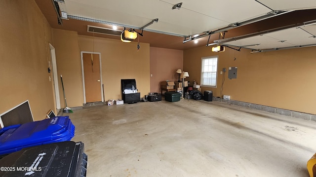 garage with a garage door opener and electric panel
