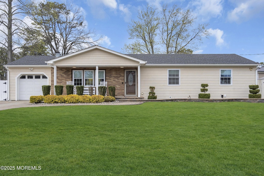 ranch-style home featuring a front lawn, driveway, covered porch, an attached garage, and roof with shingles