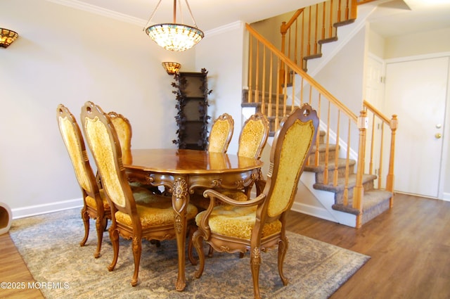 dining room with ornamental molding, wood finished floors, and stairway