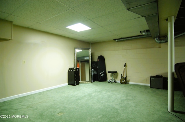 finished below grade area featuring carpet floors, a paneled ceiling, and baseboards