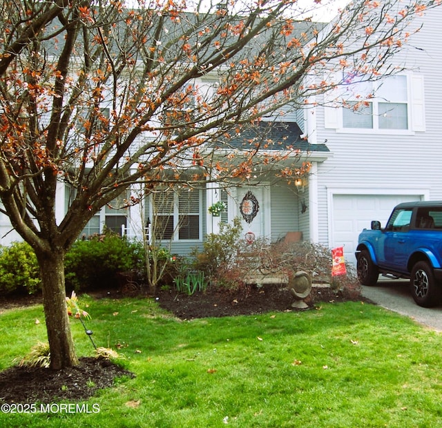 view of property hidden behind natural elements with an attached garage and a front lawn