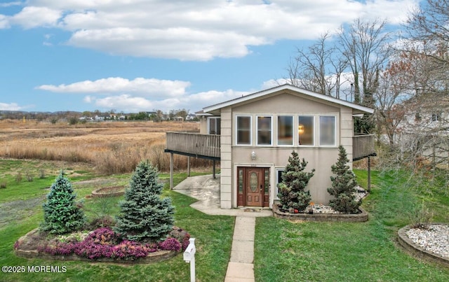 650 Front St, Union Beach, NJ 07735 - view of front facade featuring stucco siding, a front lawn, an attached carport, and a deck