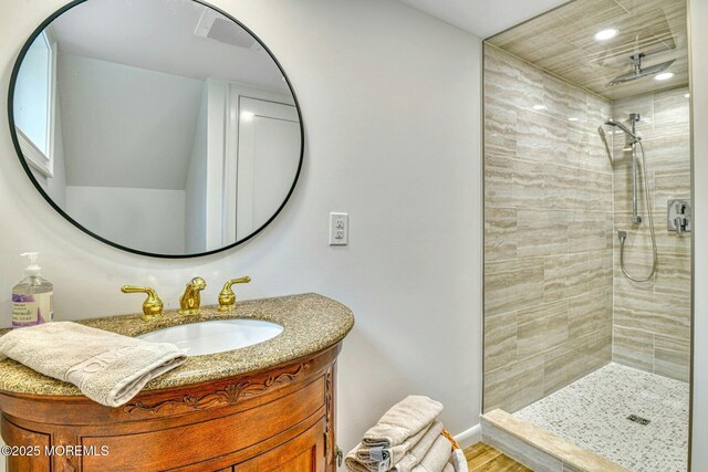 bathroom featuring recessed lighting, a tile shower, and vanity