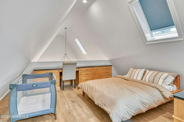 bedroom with light wood-style floors and vaulted ceiling with skylight