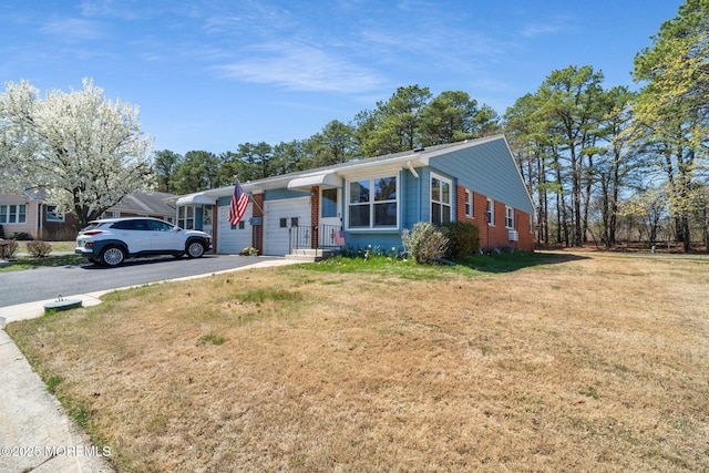 ranch-style house with a front lawn and aphalt driveway