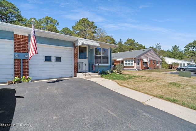 ranch-style home with an attached garage, a front yard, and driveway