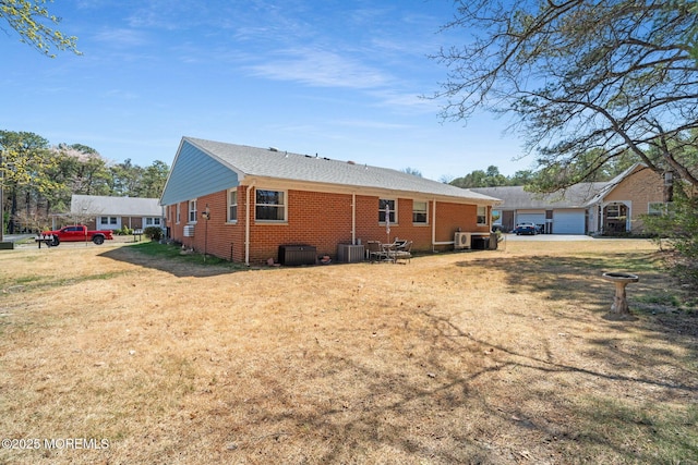 rear view of house featuring brick siding and cooling unit